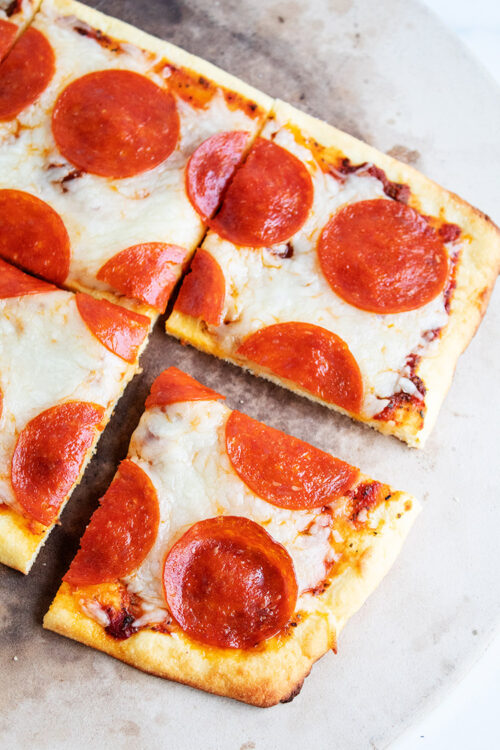 overhead view of pepperoni pizza on a pizza stone